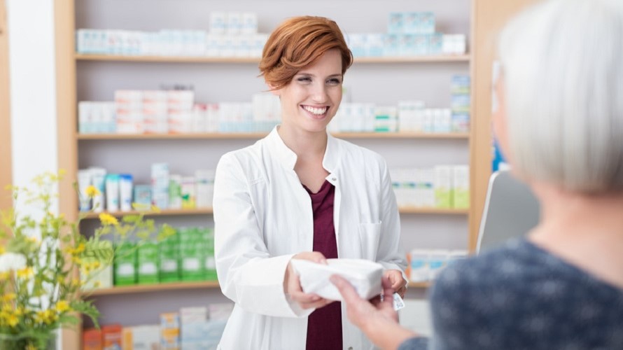 Apothekerin übergibt ihrer Kundin die Medizin Apothekerin übergibt ihrer Kundin die Medizin